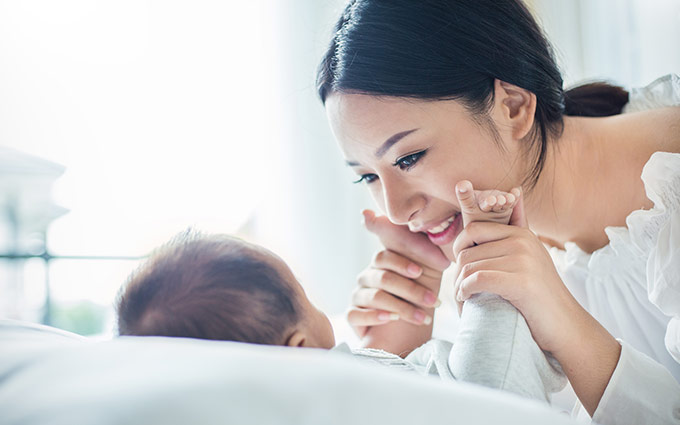 Asian mother smiling at her baby