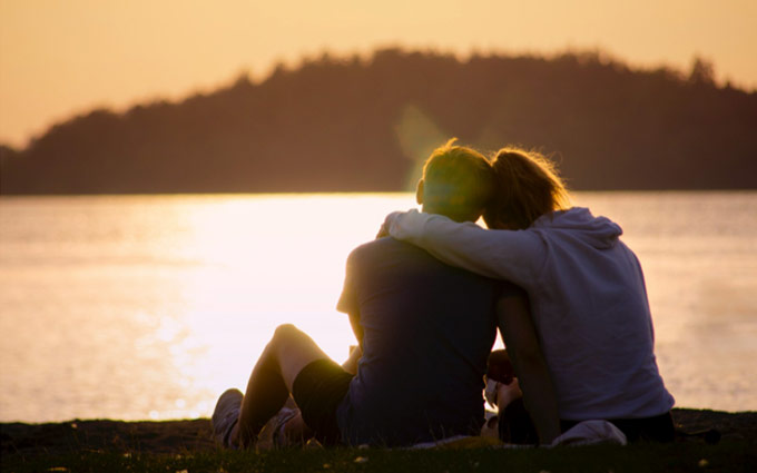 A couple sitting and watching the sunset together