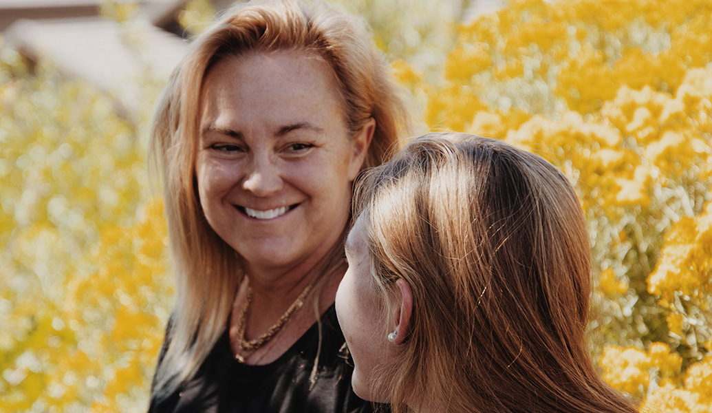 Middle age woman smiling and laughing with younger woman